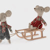 mouse pulling wooden sledge with a mouse sitting on it